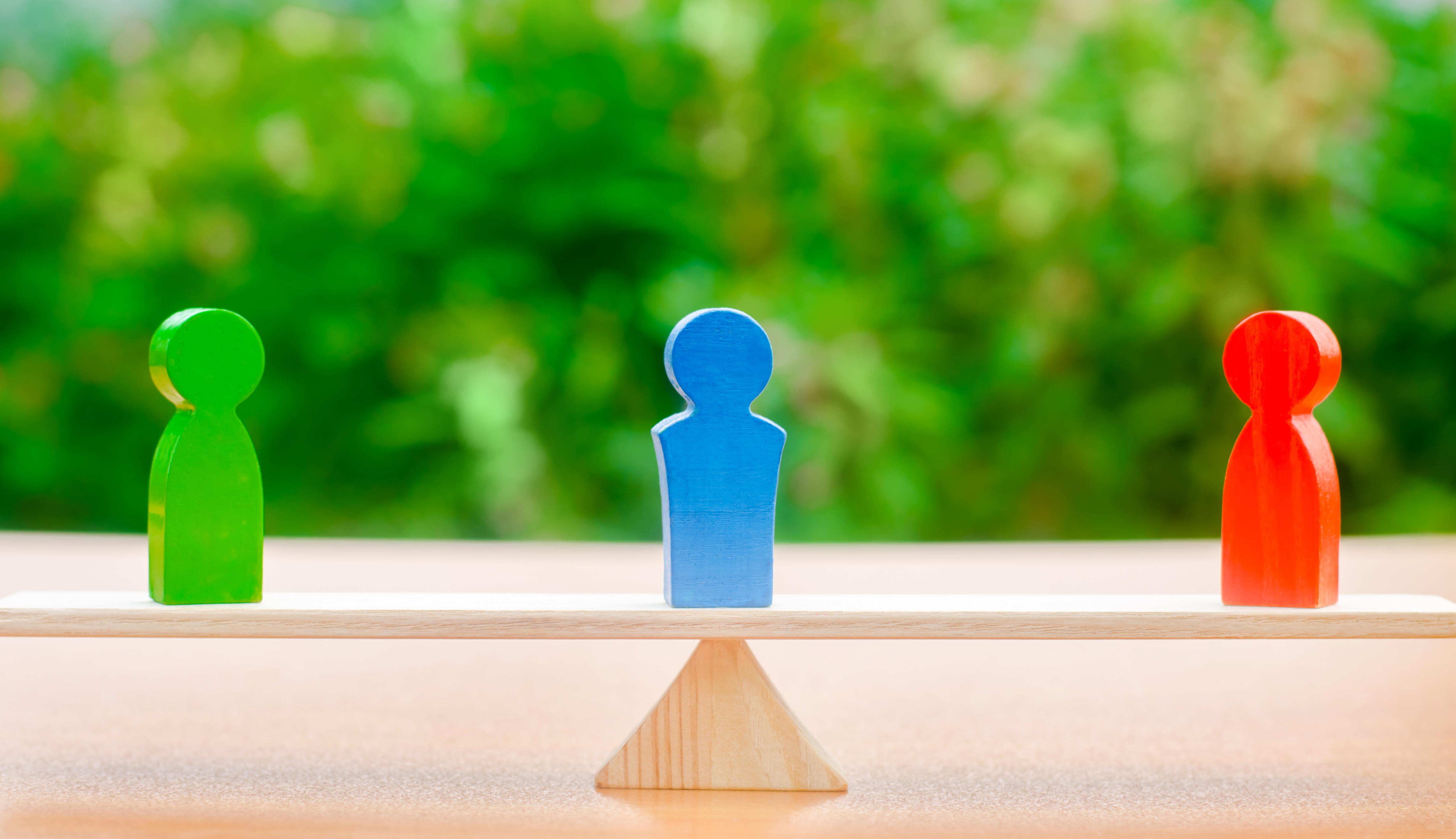 Wooden figures of people on scales and a mediator / arbitrator